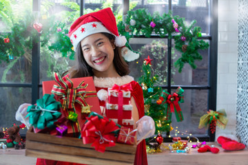 Beautiful Asian girl in christmas wearing and santa hat holding many gift boxes. Christmas concept