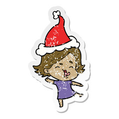 distressed sticker cartoon of a girl pulling face wearing santa hat