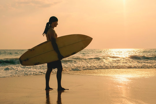 man with a surfboard goes into the ocean