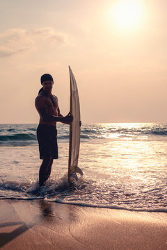 man with a surfboard goes into the ocean