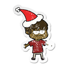 annoyed distressed sticker cartoon of a boy wearing santa hat