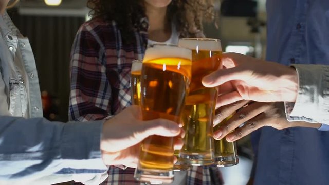 People clinking beer glasses at pub, evening with best friends, relaxation