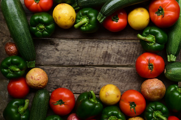 Cucumbers, tomatoes and sweet pepper on wooden table for background