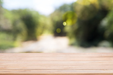 Wooden board empty table in front of blur Abstract natural green light.