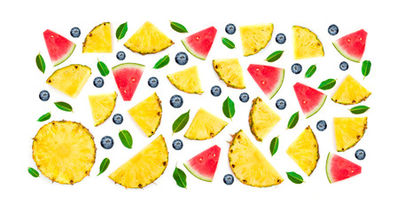 Colorful summer pattern with tropical fruits and berries. Watermelon slice, pineapple pieces,  blueberry, green leaves. Flat lay. Top view.