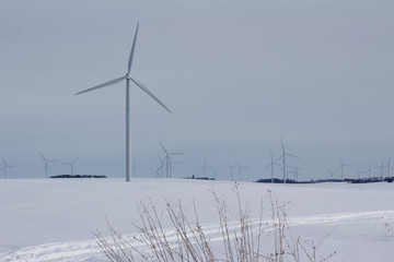 Electric wind turbines on a snowy rural field in winter