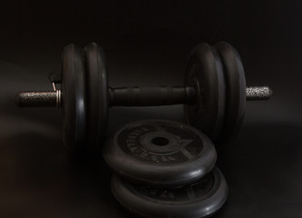 Fototapeta na wymiar Dumbbell black, steel heavy weight, item for fitness, black background
