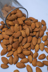 almonds on glass with white background, Indian almonds in white background, almonds were splatted out from the glass