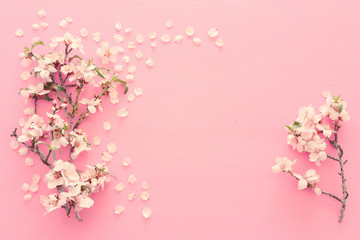 Naklejka na ściany i meble photo of spring white cherry blossom tree on pastel pink wooden background. View from above, flat lay