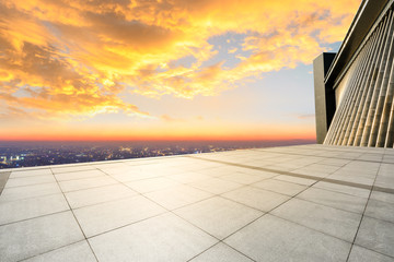 Empty square floor and modern city skyline with buildings at sunset