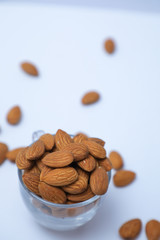 almonds on glass with white background, Indian almonds in white background, almonds at the corner