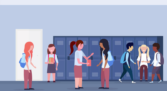 mix race schoolchildren group standing in school lobby corridor interior with row of blue lockers communication education concept horizontal full length flat