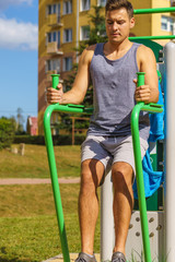 Fototapeta premium Man doing sit ups in outdoor gym