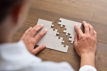 Hand placed the last piece of jigsaw puzzle, conceptual of problem solving, finding a solution 