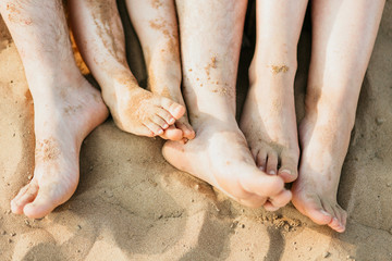Fototapeta na wymiar Closeup of feet row lying in line at summer beach