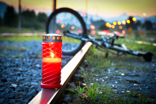 Fatal bicyclist and train crash accident when crossing rail road. Train accident with red candle and broken bicycle lying on the metal rail track