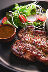 Pork steak, black pepper sauce  On a black plate. Pork steak, black pepper sauce  On a black background