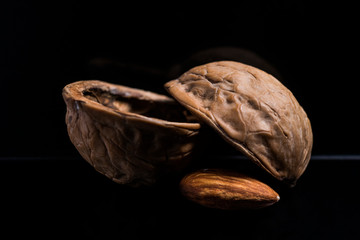 Almonds, almonds closeup on a black background with walnutshell, dry fruit.