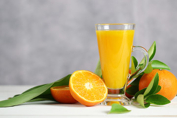 Fototapeta premium Glass of orange juice with oranges fruit on wooden table. Summer drink.