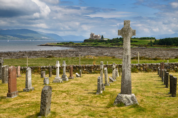 Ancient tombstones and Celtic cross at Kilpatrick Cemetery next to Duart Castle on Isle of Mull on Sound of Mull Loch Linnhe Scotland UK