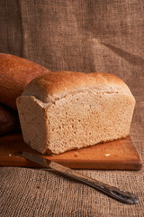 Bakery - gold rustic crusty loaves of bread and buns on black chalkboard background. Still life captured from above