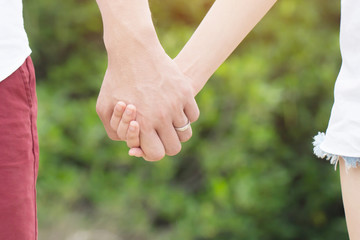 Women and man wear a ring in the finger holding hands together, Happy love in the garden. romantic atmosphere in the parks. concept couple lover valentine day. shake hands