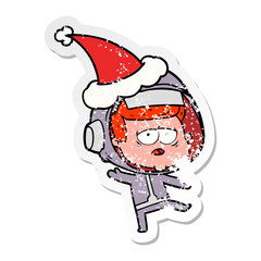 distressed sticker cartoon of a tired astronaut wearing santa hat