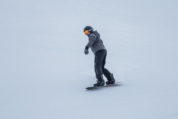 A snowboarder sliding on the slope