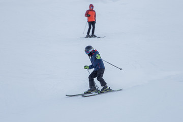Fototapeta na wymiar Two skiers skiing downhill in the Shymbulak ski resort in Kazakhstan