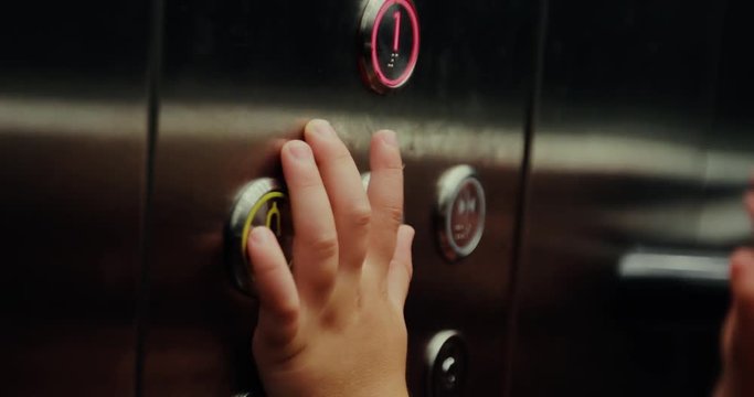 Pressing a button in an elevator. Going to the first floor. Close up shot
