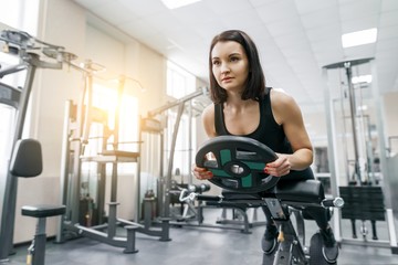 Young beautiful athletic woman brunette doing fitness exercises in the gym. Fitness, sport, training, people, healthy lifestyle concept.