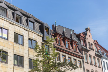 A row of beautiful unusual architecture style medieval houses with a tree before them Nuremberg