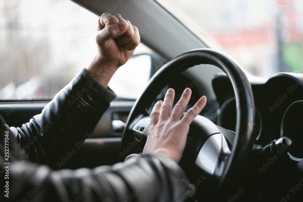 Wall mural angry driver is honking and is yelling by sitting of a steering wheel. road aggression concept. traf