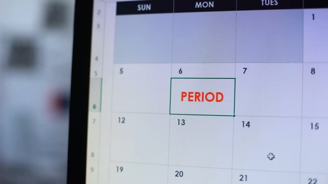 Woman scheduling period in online diary on computer, pregnancy planning, cycle