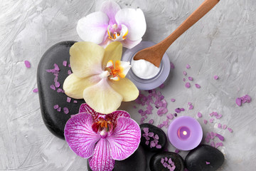 Spa stones, orchid flowers and sea salt on grey background