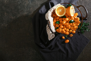 Basket with delicious kumquat fruit on table