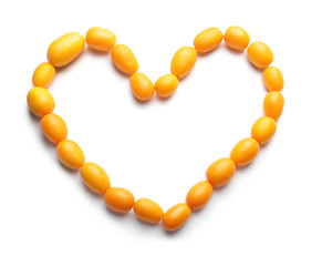 Heart made of delicious kumquat fruit on white background