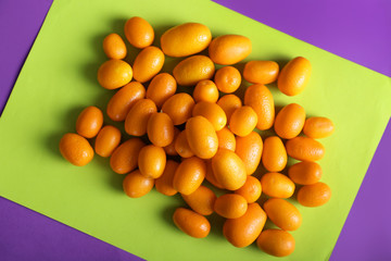 Delicious kumquat fruit on color background