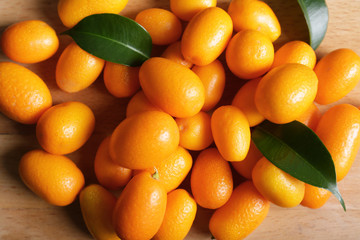 Delicious kumquat fruit on wooden background