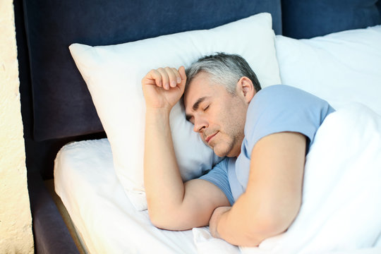 Mature Man Sleeping In Bed At Home