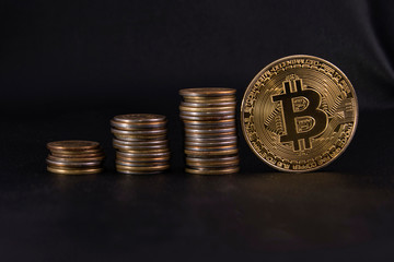 three piles of coins in ascending order, and a Golden coin bitcoin on black leather