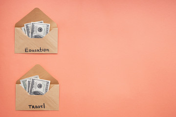 Envelopes with money for different needs on color background. Concept of savings