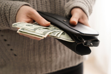 Woman holding wallet with money, closeup