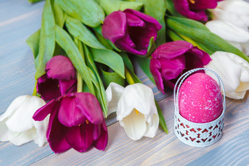 Easter eggs with tulips on blue wooden background