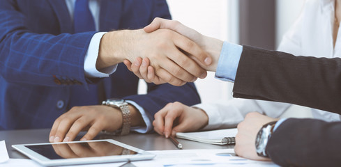 Business people shaking hands, finishing up a papers signing. Meeting, agreement and lawyer consulting concept