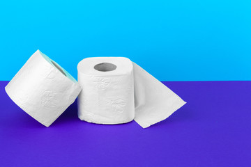 Toilet paper rolls isolated on white table with purple background