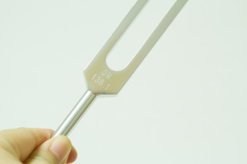 Hand holding a tuning fork .