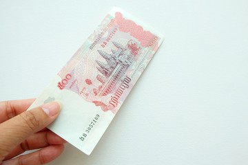 Woman hand holding Cambodia banknote on white background. 