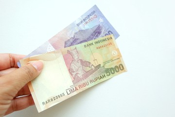 Woman hand holding  Indonesia banknote on white background. 