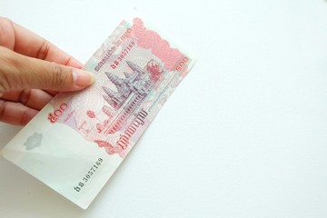 Woman hand holding Cambodia banknote on white background. 
